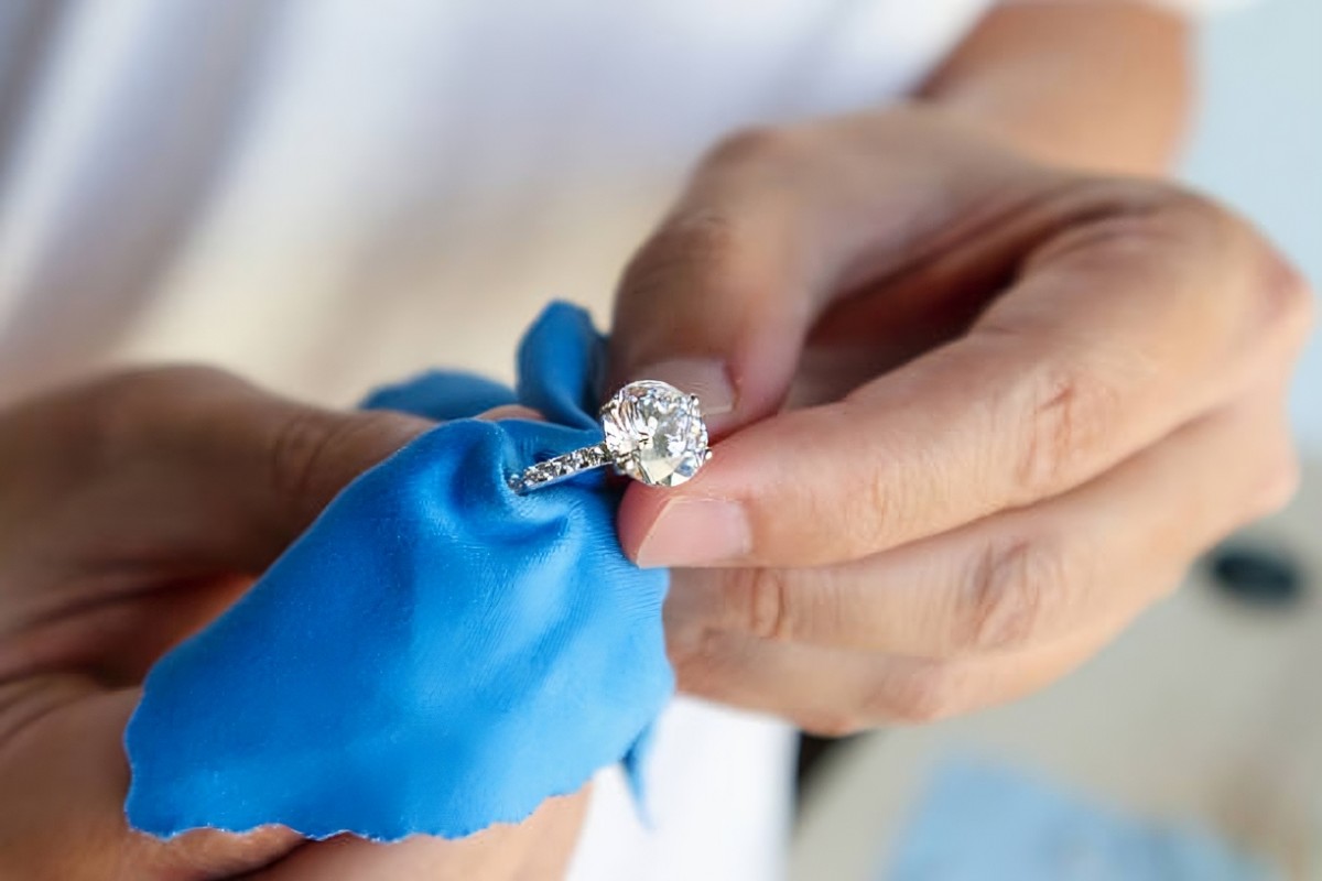 Nettoyage d’une bague en or avec un chiffon doux en microfibre pour raviver l’éclat du diamant